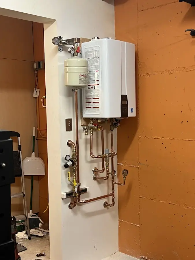 Plumbing technician inspecting water heater connections in Marianna